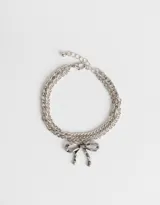 Pulsera plateada de eslabones dobles con dije de moño.