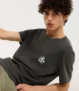 Remera masculina de algodón color gris oscuro, modelo comfort, con cuello redondo y mangas cortas. Estampa frontal con palmeras y lettering "El Cuco" en blanco.