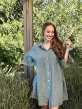 Vestido camisero color verde agua, de lino italiano, con cuello camisero, botones frontales, mangas cortas con doble volado y bolsillos laterales.