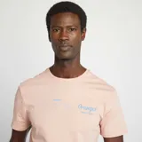 Camiseta rosa pálido de manga corta con cuello redondo y estampado pequeño en el pecho con la palabra "Oranges".