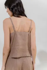Musculosa de lino color crudo con rayas verticales finas en negro, escote en V y breteles finos regulables con detalle de borlas.
