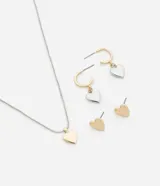 Conjunto de bisutería plateada y dorada con colgantes y aros con forma de corazón. Incluye un collar con dije de corazón dorado, un par de aros tipo argolla con dije de corazón plateado y un par de aros tipo botón con forma de corazón dorado.