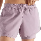 Short deportivo 2 en 1 New Balance color lila, con calza interior ajustada y short exterior holgado.
