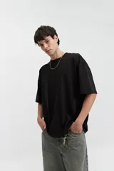 Remera de manga corta color marrón claro, de corte amplio y cuello redondo.