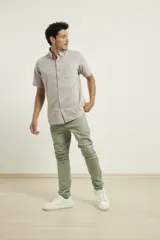 Camisa manga corta color gris claro con textura, cuello abotonado y bolsillo en el pecho.