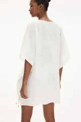 Túnica playera blanca de manga corta con escote en V y cordones ajustables en la cintura.