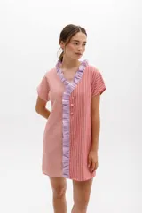 Vestido corto con rayas verticales y horizontales en tonos grises y blancos, con volados color lima en el escote y cierre frontal con botones.