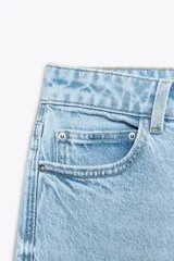 Pantalón de jean negro de corte recto, tiro alto y largo tobillero.