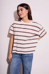 Remera de algodón color crudo con rayas horizontales marrones, corte oversize y mangas cortas.