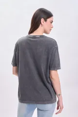 Remera gris oscuro con cuello redondo y tachas plateadas alrededor del cuello.