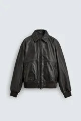 Cazadora bomber de piel color marrón oscuro envejecido, con cuello solapa, cierre frontal de cremallera y puños y bajo en rib elástico. Presenta grabados en relieve en el delantero y la espalda.