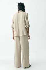 Pantalón marrón de tiro alto con cintura elástica y pierna ancha.