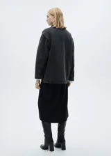 Chaqueta oversize de algodón negro con cuello camisero de pana, cierre frontal con cremallera y botones a presión, bolsillos de parche con solapa y bolsillos de ribete.