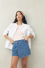 Short pollera de denim azul con corte asimétrico y cierre con botón.