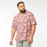 Camisa de manga corta color terracota con estampado de palmeras en blanco.