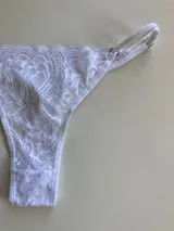 Bombacha colaless de encaje blanco con tiras ajustables en los costados.