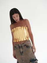 Top strapless de cuero color dorado con tablitas y elástico en la espalda.