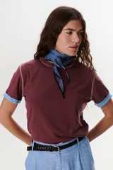 Remera blanca de manga corta con cuello redondo y detalle de costuras en contraste en cuello y mangas.