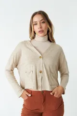 Cardigan tejido color beige con escote en V, cierre con botones, bolsillos delanteros y logo en grifa de cuero.