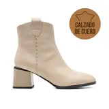 Bota de cuero negra con caña baja, punta fina y taco geométrico.