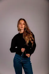 Buzo gris de punto con cuello redondo, mangas largas abullonadas y cierre frontal asimétrico.