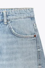 Pantalón de jean celeste de corte amplio, con tiro medio, cinco bolsillos y costuras torcidas.