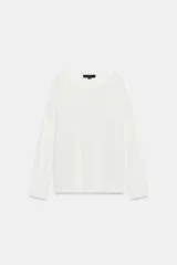 Jersey de punto liso, color azul brillante, con cuello redondo y manga larga. Presenta acabados en rib en puños, cuello y bajo, con aberturas laterales en el ruedo.