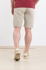 Bermuda verde militar de corte regular con cinco bolsillos, confeccionada en algodón con lavado.