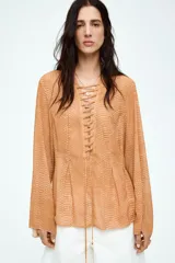 Blusa de gasa color ocre con estampado de piel de serpiente, escote en V pronunciado con tiras diagonales y mangas extralargas acampanadas.