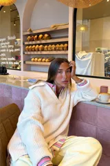 Buzo de punto color crudo con cuello polo y aberturas laterales.