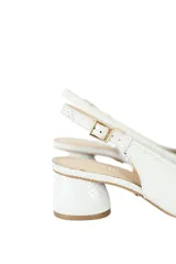 Zapato de tacón color blanco con textura de piel de serpiente, talón descubierto y tira trasera con hebilla.
