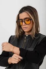 Campera negra con cuerpo de cuero y mangas de tejido de punto. Tiene cuello redondo, cierre frontal con cremallera, dos bolsillos con cremallera en el pecho y costuras decorativas en los hombros.