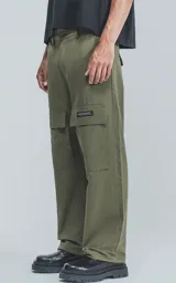 Pantalón verde militar de corte recto con bolsillos cargo laterales y etiqueta con logo en la pierna derecha.