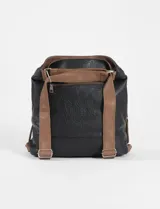Cartera convertible en mochila color natural, con correa de hombro marrón y detalles de cierres metálicos.