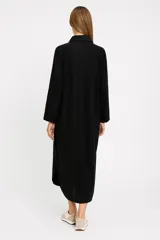 Túnica midi color beige de lino, corte holgado, manga larga, cuello camisero y cierre frontal con botones.