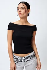 Top tejido color blanco con escote bardot que deja los hombros al descubierto y punto acanalado.