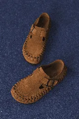 Zapato marrón de cuero con hebilla y detalle de trenzado en la suela.