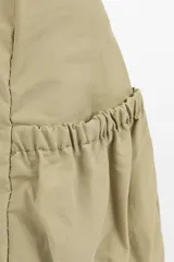 Bandolera color beige con múltiples bolsillos con cierre en la parte frontal y trasera, y bolsillos ajustables en los laterales.