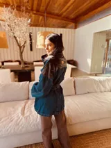 Campera tipo trench de jean con corte oversized y cinturón. Presenta espalda y cuello de cuero ovino.