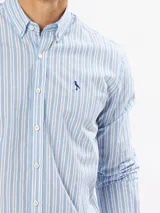 Camisa celeste a rayas verticales blancas, de corte slim fit y manga larga.