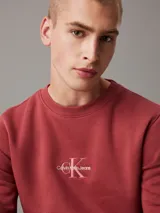 Buzo de felpa color ladrillo con cuello redondo, puños y bajo acanalados. Presenta un logo bordado de Calvin Klein Jeans en el pecho.