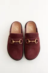 Mocasines tipo sueco de cuero gris con detalle de hebilla dorada.
