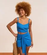 Blusa cropped de viscolino azul con escote en V, breteles con adornos y lastex en la espalda.