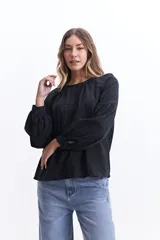 Blusa blanca de manga larga con detalle de tablas en el frente y puños.