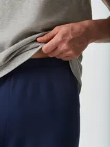 Pijama gris compuesto por una remera de manga corta con cuello redondo y un pantalón largo. La remera tiene un pequeño bordado en el pecho.