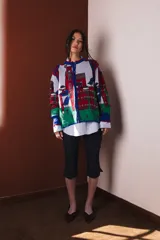Cárdigan tejido en jacquard con diseño de casas en tonos gris, rojo, verde y azul.