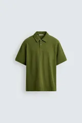 Polo verde oliva de tejido piqué, corte regular fit, cuello solapa con cierre frontal de botonadura y manga corta.