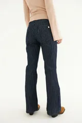 Pantalón jean de tiro alto con corte Oxford, color azul con finas rayas verticales blancas. Presenta etiqueta de cuero con logo de la marca en la parte trasera de la cintura y detalle metálico en el bolsillo trasero.