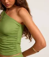 Blusa verde de rib con escote asimétrico de un solo hombro y manga larga.