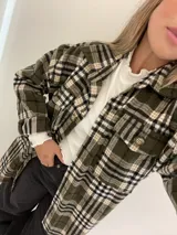 Remera gris de morley de algodón, de manga larga, con terminaciones fruncidas en cuello y mangas.